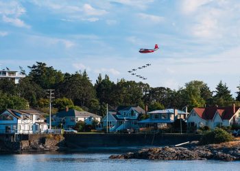 Firefighting aircraft over a coastal settlement