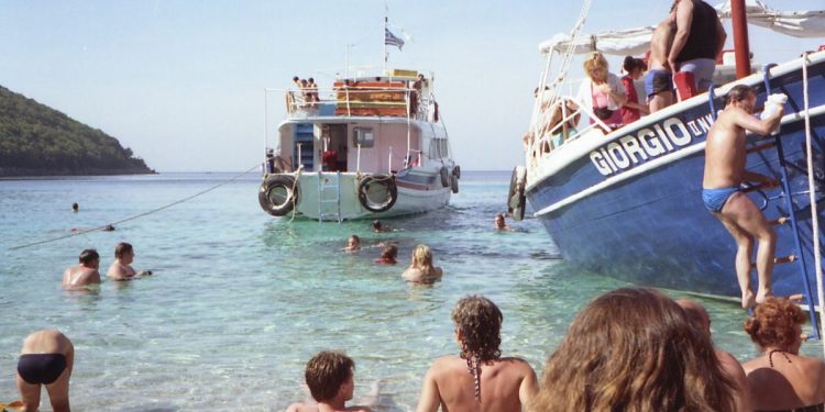 Greek Island Hopping Itinerary: Routes, Ferries and a 7-Day Plan 1 Passengers swimming beside a boat moored off a Greek island