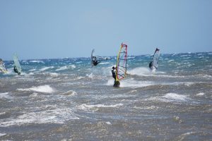 Greek Islands in August: the Meltemi, the Heat and Your Ferry 25 Windsurfers on a choppy Aegean shore