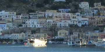 Kalimnos'un limanı Pothia'da tekneler ve yamaca sıralanan renkli evler